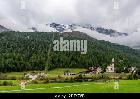 Panoramablick auf Solda, Südtirol, Italien, seine Pfarrkirche am See, mit den Ortlerbergen im Hintergrund Stockfoto