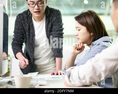 Team von asiatischen Männern und Frauen diskutieren Geschäft im Büro Stockfoto