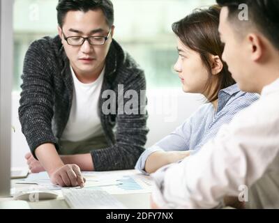 Team von asiatischen Männern und Frauen diskutieren Geschäft im Büro Stockfoto