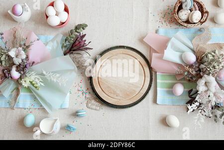Osterkomposition mit Blumen, Eiern und Holzfläche für Text in Pastellfarben flach legen. Stockfoto