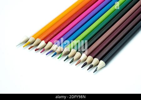 Eine Gruppe mehrfarbiger Bleistifte, isoliert auf weißem Hintergrund. Haufen von verschiedenen Schulbedarf in Regenbogen Anordnung. Zurück zur Schule und creativi Stockfoto