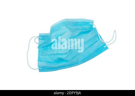 Gebrauchte blaue medizinische Vliesstoff Gesichtsmaske mit elastischen Ohrbügel auf weiß isoliert. Plastikverschmutzungsproblem. Covid-19 Umweltproblem. Stockfoto