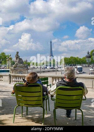 Das Paar sitzt auf dem Eiffelturm über dem Place de la Concorde in Paris, Frankreich Stockfoto