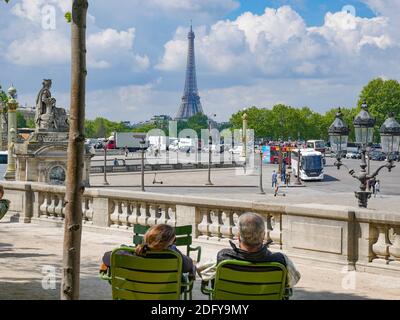 Das Paar sitzt auf dem Eiffelturm über dem Place de la Concorde in Paris, Frankreich Stockfoto