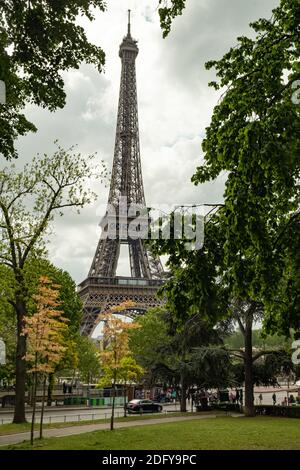 Der Eifel-Turm erblickte im Trocadero Park, Paris, die blühenden Bäume im Sprint. Aufgenommen an einem hellen, aber bewölkten Tag Stockfoto