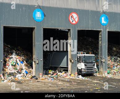 Weißer Müllwagen zum Entladen von Abfällen im Lager. Abfallsortierung. Recycling. Umweltschutz. Stockfoto