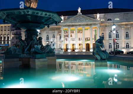 Spiegelung des Zeichens des Nationaltheaters am beleuchteten Brunnen am Rossio-Platz in Lissabon, Portugal. Nachts aufgenommen Stockfoto