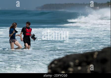 VARKALA, INDIEN - 14. März 2020: Zwei Fotografen, die am Strand spazieren, um die Surfer in Aktion festzuhalten Stockfoto