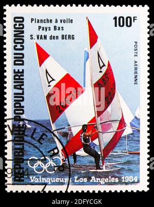 MOSKAU, RUSSLAND - 28. AUGUST 2020: Briefmarke gedruckt im Kongo zeigt Olympia Los Angeles -84, S. vd Berg Niederlande, Windsurfen, Windsurfen seri Stockfoto