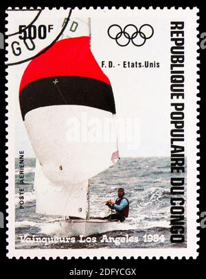 MOSKAU, RUSSLAND - 28. AUGUST 2020: Briefmarke gedruckt im Kongo zeigt Olympia Los Angeles '84, USA, Flying Dutchman, Windsurfing Serie, cir Stockfoto