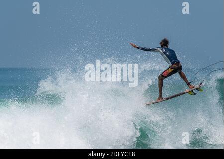 VARKALA, INDIEN - Mär 14, 2020: Ein indischer Surfer macht einen Flip über eine riesige Welle. Stockfoto
