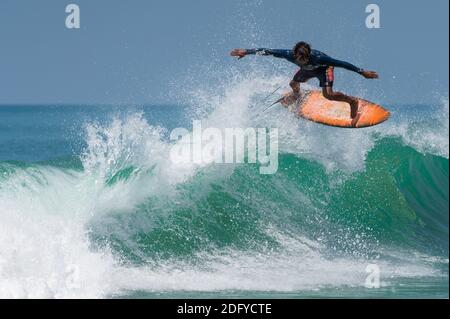 VARKALA, INDIEN - Mär 14, 2020: Ein indischer Surfer macht einen Flip über eine riesige Welle. Stockfoto