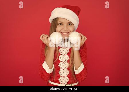 Der Geist von Weihnachten definieren. Glückliches Kind Weihnachten halten Baum Kugeln. Kleines Mädchen Weihnachtsbaum schmücken. Frohe Weihnachten und ein glückliches neues Jahr. Heiligabend. Der Weihnachtszeit. X-mas. Weihnachten Dekorationen und Verzierungen. Stockfoto