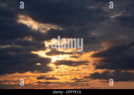 Dramatischer dunkler Himmel und orange Sonnenuntergangsfarbe. Kontrast unscharfer natürlicher Hintergrund. Stockfoto