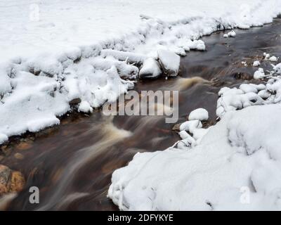 Strom in Bewegung, Wasser verschwimmen. Winter Bergbach in Karelien fließt durch den Wald. Die Kraft der wilden majestätischen Natur. Wasserturbulenzen Stockfoto