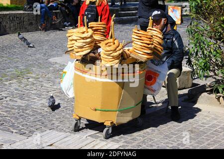 Mann, der Sesambrotringe in der Dionysiou Areopagitou Straße in Athen, Griechenland, verkauft, 3. März 2020. Stockfoto