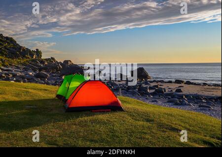 Camping bei Sonnenuntergang mit Zelten am Strand von Utakleiv auf den Lofoten, Norwegen Stockfoto