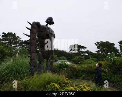 Im Hayao Miyazaki Studio Ghibli Museum starrt ein Mädchen am Himmel auf eine Skulptur des Eisernen Riesen aus dem Schloss Laputa. Stockfoto