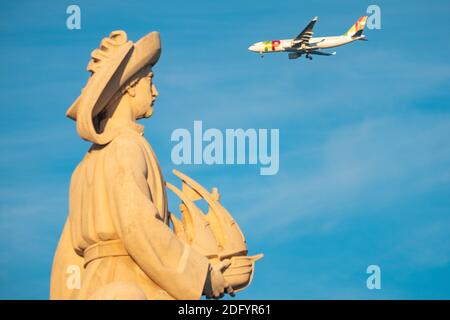 Lange Aufnahme eines Flugzeugs hinter dem Kopf vorbei Henry der Seefahrer auf dem Denkmal für die Entdecker in Lissabon Portugal Stockfoto