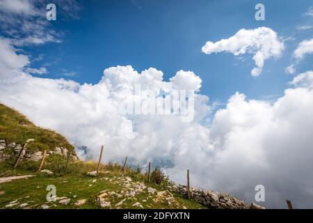 Schöne Cumuluswolken (Cumulonimbus) am blauen Himmel in Berg, Monte Baldo, Bergkette zwischen Gardasee und Etschtal. Verona, Italien. Stockfoto