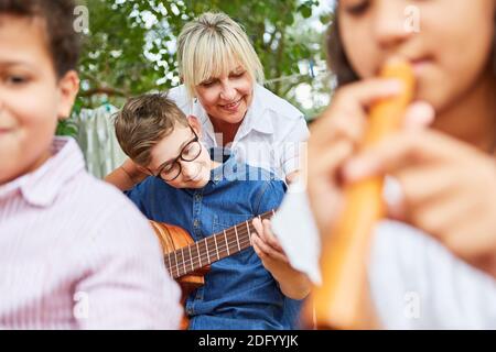 Lehrer und Kinder zusammen im Musikunterricht in Sommercamps Stockfoto