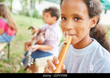 Mädchen lernt, Flöte mit Freunden in der Musik zu spielen Kurs im Sommer Camp Kurs Stockfoto