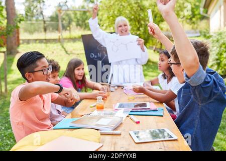 Die fröhliche Gruppe der Kinder und des Lehrers in der Sommerschule in Chemie-Klasse Stockfoto