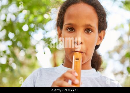Mädchen übt Flötenspiel im Musikunterricht im Sommer Camp oder Sommercamp Stockfoto