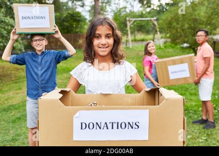 Kinder sammeln als Freiwillige Spenden für eine Bekleidungskollektion Stockfoto