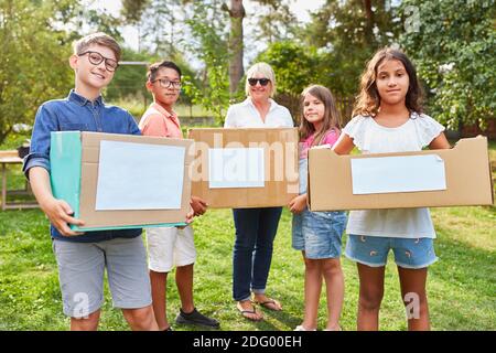 Gruppe von Kindern als freiwillige Helfer in Spendenaktion sammeln Spenden und alte Kleidung Stockfoto