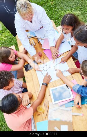 Kinder Gruppe in Chemie-Klasse mit Lehrer im Sommer Tutoring Sommerschule Stockfoto