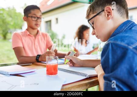 Kinder studieren und schreiben einen Test in der Chemie-Tutoring-Klasse Im Urlaub Kurs Stockfoto