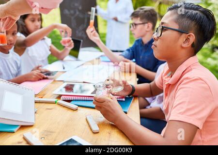 Gruppe Kinder in multikulturellen Sommerschule in Chemie Nachhilfe Klasse Stockfoto