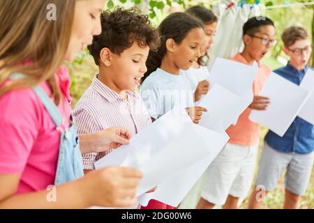 Kinder singen gemeinsam im Chor des Sommerlagers Auf Talentshow Stockfoto