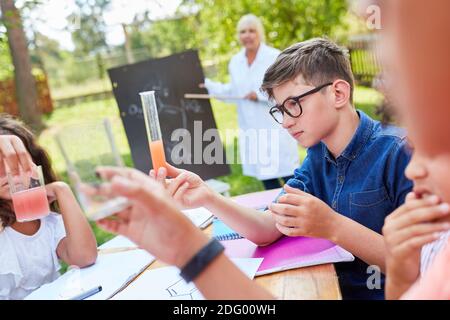 Kinder lernen gemeinsam im Chemie-Tutoring-Ferienkurs und Führen Sie Experimente durch Stockfoto