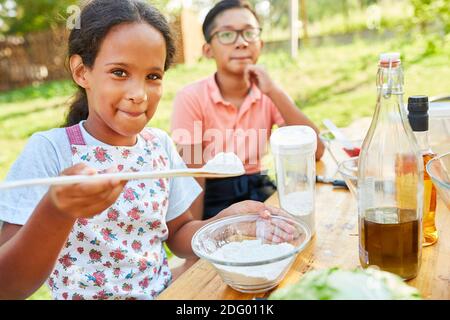 Kinder lernen gesund zu kochen und bereiten Salat in der Ernährungskurs im Sommercamp Stockfoto