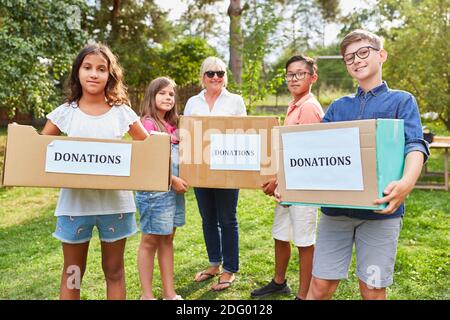 Kinder als freiwillige Helfer sammeln Spenden für die Kleidersammlung Stockfoto