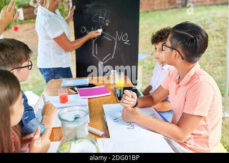 Chalkboard Lehrer unterrichtet Chemie im Sommerschule Tutoring Camp Stockfoto