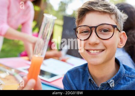 Junge hält ein Reagenzglas während eines Experiments in Chemie Sommer Nachhilfekurs Stockfoto