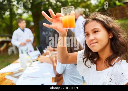 Mädchen macht Experiment mit einer Flüssigkeit in der Chemie-Klasse in Sommerschule Stockfoto