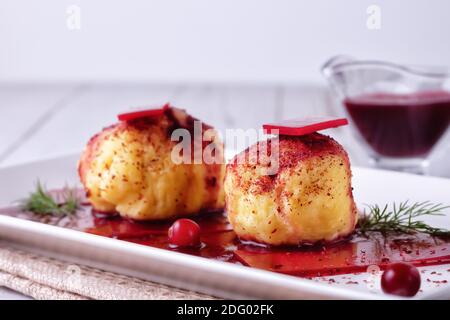 Frisch gekochte schwedische Kartoffelknödel mit Preiselbeersauce auf hellem Hintergrund. Stockfoto