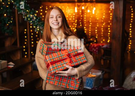 Nahaufnahme Porträt von fröhlichen Rotschopf junge Frau hält viele schöne Geschenkschachteln für Weihnachten Stockfoto