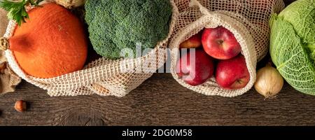 Panorama-Header von frischem Gemüse und Obst in ökologischen wiederverwendbar Netztaschen aus Bio-Baumwolle auf einem Holzhintergrund Stockfoto