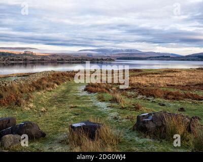 Blick über Loch Doon auf den schneebedeckten Benbrack in Dumfries und Galloway Stockfoto