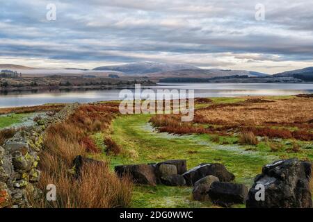 Blick über Loch Doon auf den schneebedeckten Benbrack in Dumfries und Galloway Stockfoto