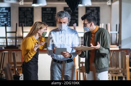 Frustrierter Besitzer, Manager streitet sich mit dem Kellner im geschlossenen Cafe, kleine Unternehmen wurden wegen des Coronavirus geschlossen. Stockfoto