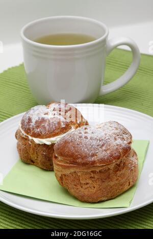 Zwei Profiterolen und Tee Stockfoto