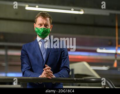 Ottendorf Okrilla, Deutschland. Dezember 2020. Michael Kretschmer (CDU, rechts), Ministerpräsident von Sachsen, steht bei seinem Besuch im DHL-Paketzentrum an einem Transportband für Pakete und trägt einen Mund- und Nasenschutz. Quelle: Robert Michael/dpa-Zentralbild/dpa/Alamy Live News Stockfoto