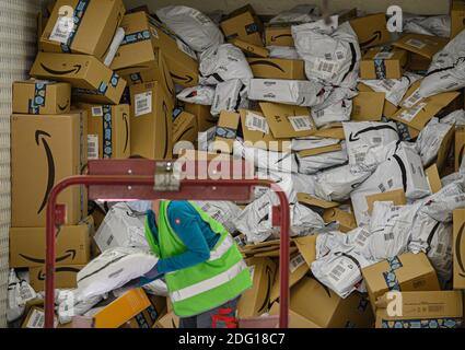 Ottendorf Okrilla, Deutschland. Dezember 2020. Amazon-Pakete werden von einem Mitarbeiter im DHL-Paketcenter von einem LKW auf ein Förderband verladen. In der Zeit vor Weihnachten nimmt das Paketvolumen deutlich zu. Quelle: Robert Michael/dpa-Zentralbild/dpa/Alamy Live News Stockfoto
