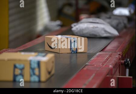 Ottendorf Okrilla, Deutschland. Dezember 2020. Amazon-Pakete befinden sich auf einem Förderband im DHL Paketcenter. In der Zeit vor Weihnachten nimmt das Paketvolumen deutlich zu. Quelle: Robert Michael/dpa-Zentralbild/dpa/Alamy Live News Stockfoto